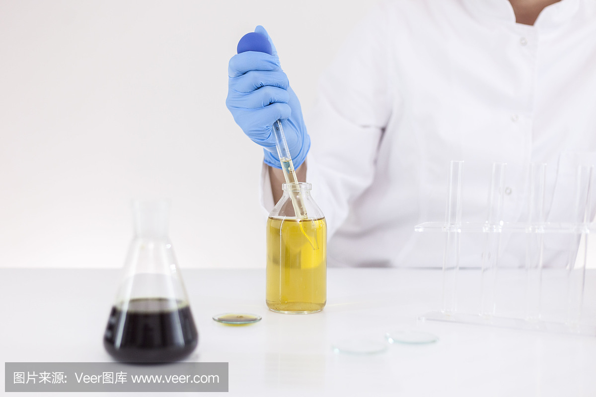 一个女性科学家在实验室工作与cbd油提取大麻植物使用玻璃滴管,管和碗的特写。医疗制药医用大麻